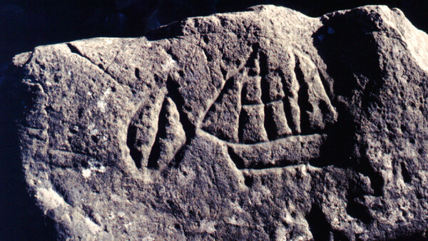 A historical Makah Tribe petroglyph features a sailing ship on a jagged rock