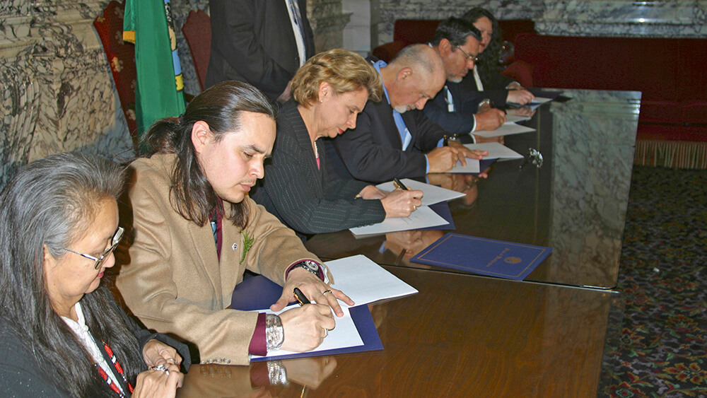 people sitting at a table signing documents