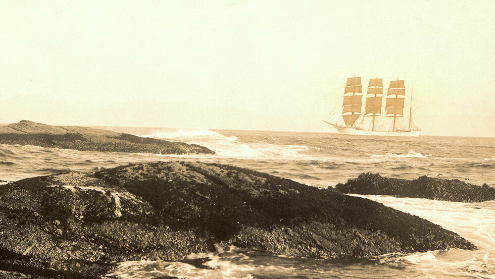 an old picture of a three masted ship sailing off a coast