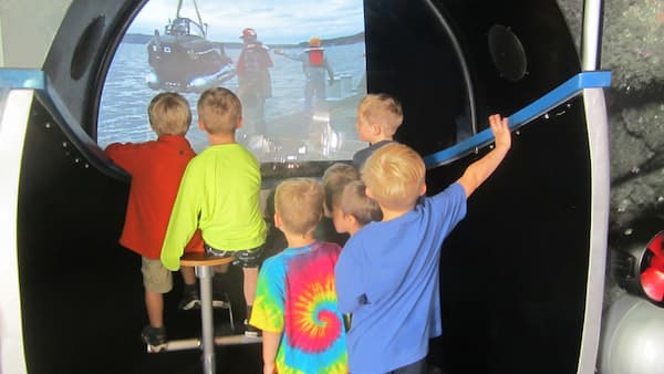 Kids watching a video of s submersible being launched into the ocean